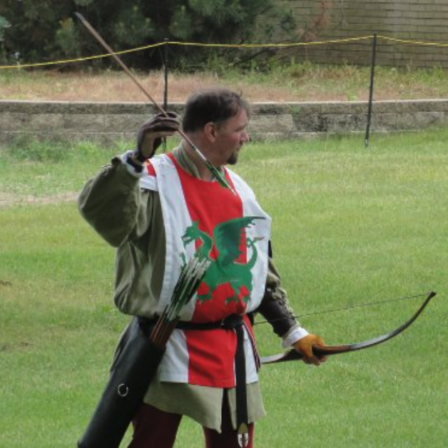 The archery champion prepares to nock his arrow, dressed in the dragon tabard of the kingdom of the middle.