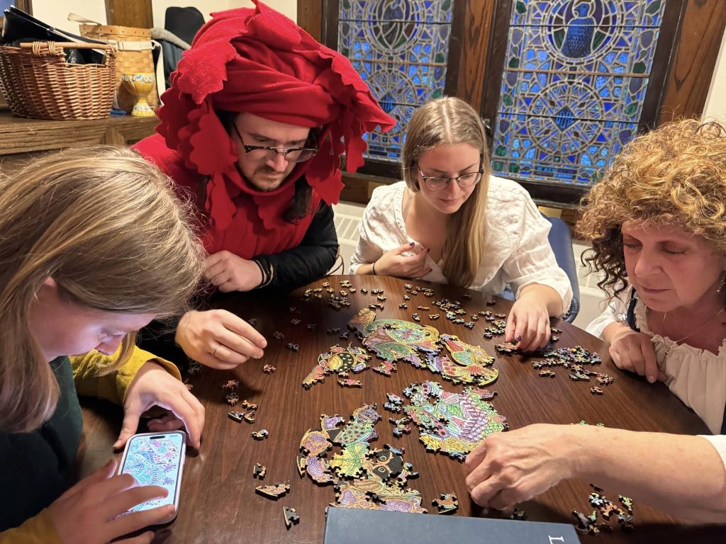 Members of the populace work on a puzzle together.